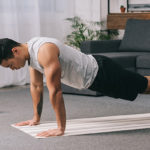 Man doing push ups in sportswear on fitness mat